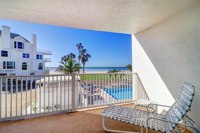 balcony featuring a water view and a beach view