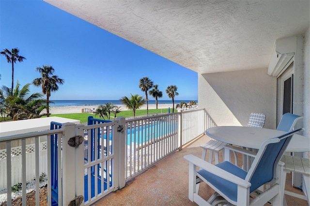 balcony with a water view and a beach view