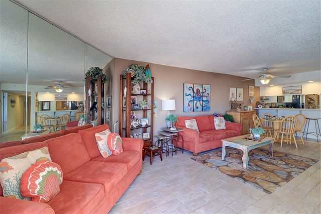 living room featuring ceiling fan and a textured ceiling