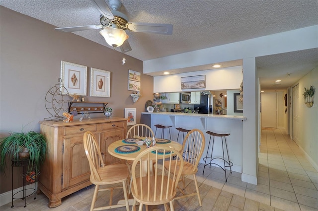 dining space featuring light tile patterned floors, a textured ceiling, and ceiling fan