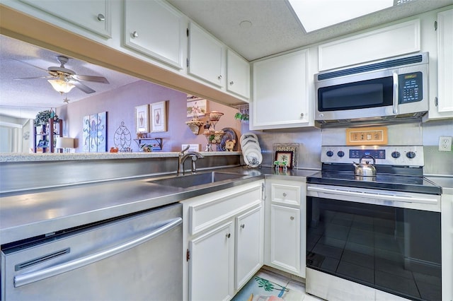 kitchen with white cabinets, appliances with stainless steel finishes, a textured ceiling, and sink