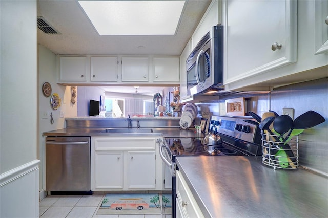 kitchen with white cabinets, stainless steel counters, sink, and appliances with stainless steel finishes