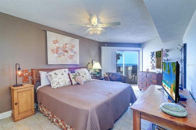 bedroom featuring a textured ceiling, access to outside, and ceiling fan