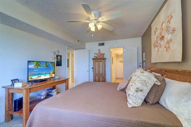 tiled bedroom featuring ceiling fan and a textured ceiling