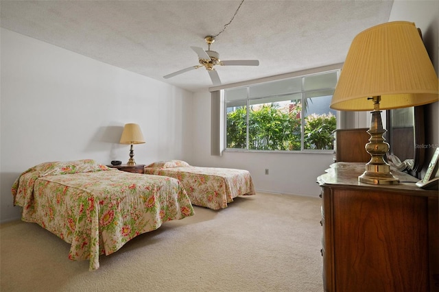 carpeted bedroom with ceiling fan and a textured ceiling