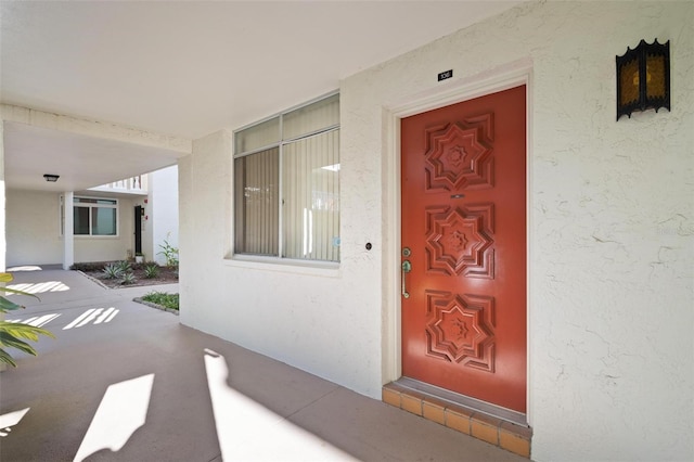 doorway to property featuring stucco siding