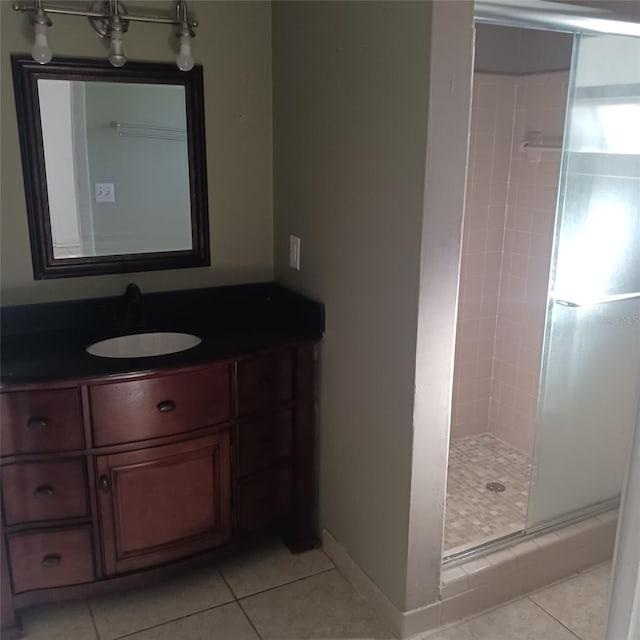 bathroom with tile patterned flooring, vanity, and an enclosed shower