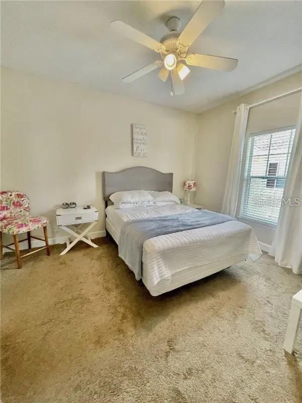 bedroom featuring ceiling fan and carpet