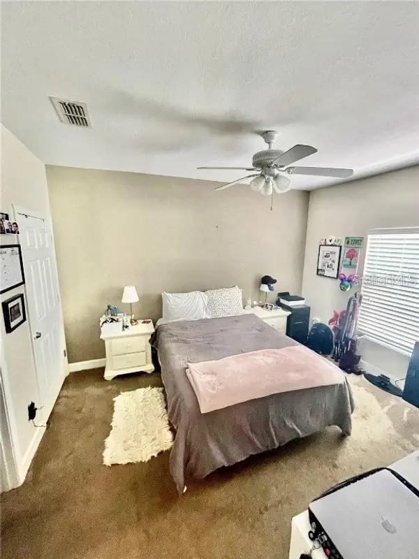 carpeted bedroom with ceiling fan