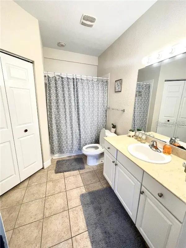 bathroom featuring tile patterned floors, vanity, toilet, and curtained shower