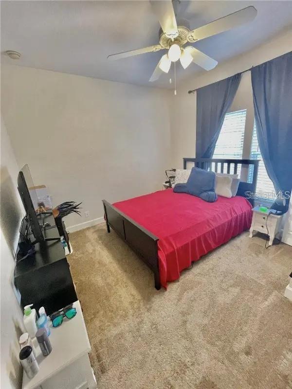 carpeted bedroom featuring ceiling fan