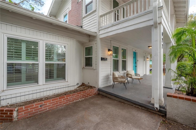 view of patio featuring a porch and a balcony