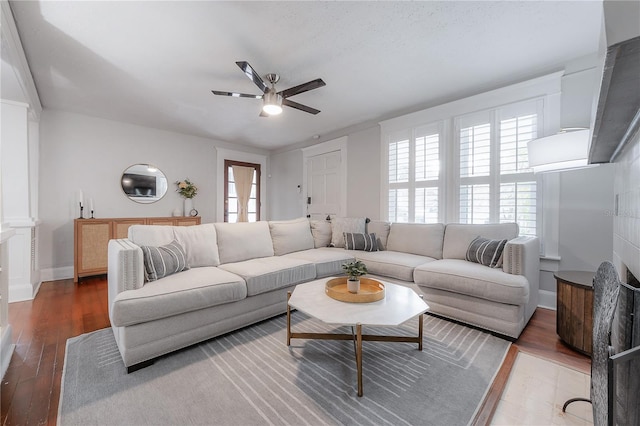 living room featuring ceiling fan and dark hardwood / wood-style flooring