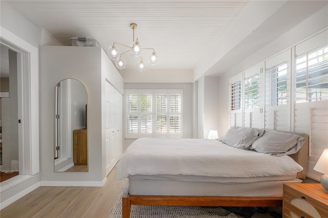 bedroom with an inviting chandelier and light hardwood / wood-style floors