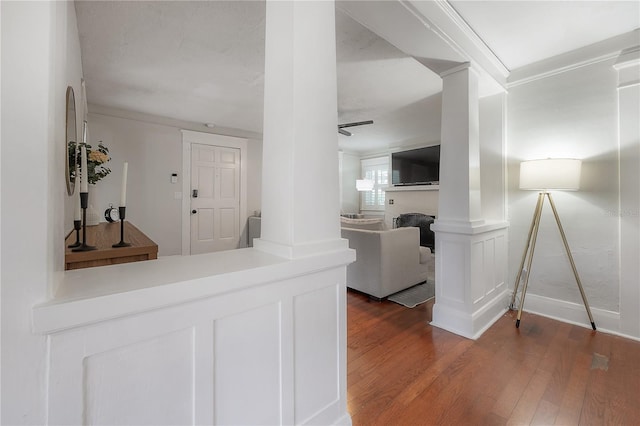 interior space with ceiling fan, crown molding, dark hardwood / wood-style floors, and ornate columns