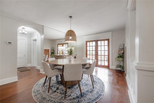 dining space featuring french doors, dark hardwood / wood-style flooring, and ornamental molding