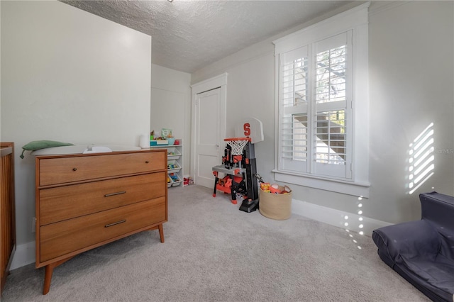 interior space with a textured ceiling and light carpet