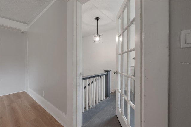 corridor featuring wood-type flooring and a textured ceiling