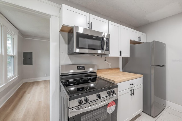 kitchen featuring butcher block counters, white cabinets, a textured ceiling, electric panel, and appliances with stainless steel finishes