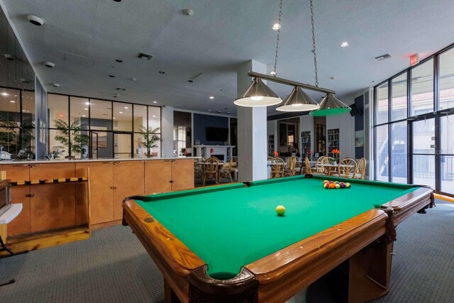 playroom featuring a textured ceiling, carpet floors, floor to ceiling windows, and pool table