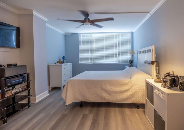 bedroom featuring hardwood / wood-style floors, ceiling fan, and crown molding