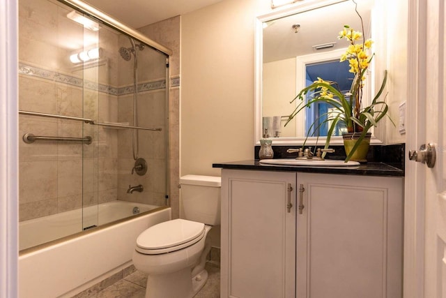 full bathroom featuring tile patterned floors, combined bath / shower with glass door, toilet, and vanity