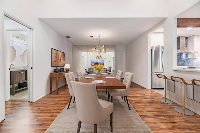 dining area with wood-type flooring and a chandelier