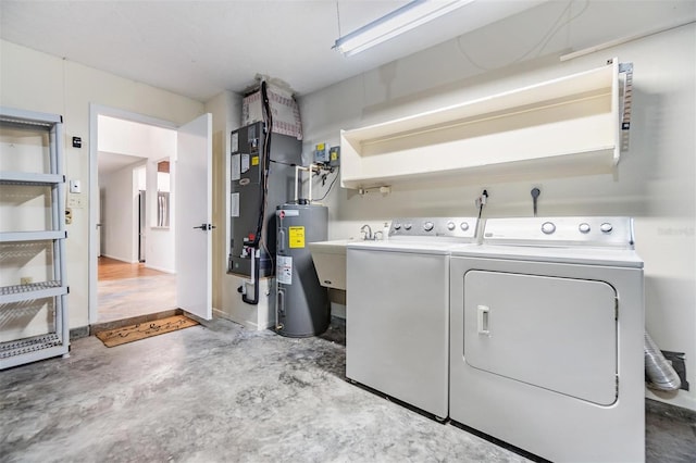 washroom featuring electric water heater, sink, and independent washer and dryer