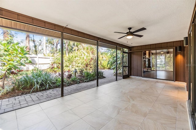 unfurnished sunroom featuring ceiling fan