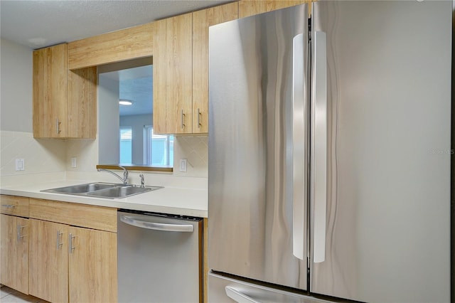 kitchen with backsplash, sink, stainless steel appliances, and light brown cabinetry