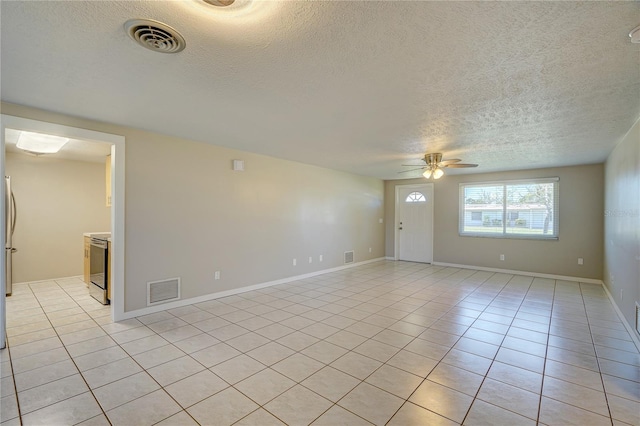 tiled empty room featuring a textured ceiling and ceiling fan