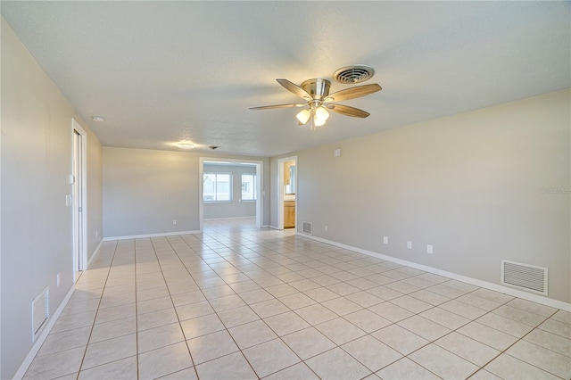 tiled spare room with ceiling fan and a textured ceiling