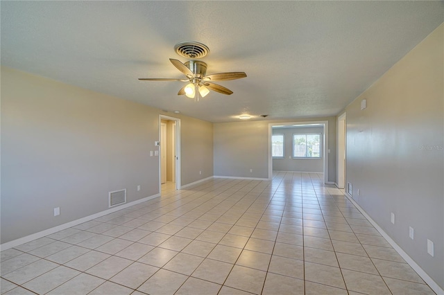 empty room with ceiling fan and light tile patterned floors