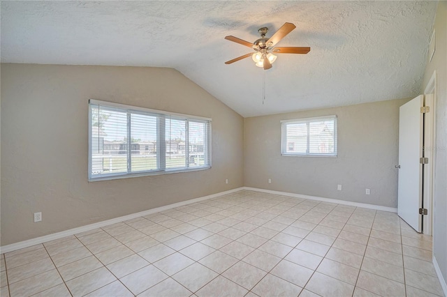 empty room with light tile patterned floors, a textured ceiling, vaulted ceiling, and ceiling fan