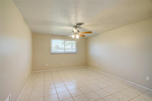 unfurnished room with ceiling fan, light tile patterned floors, and a textured ceiling