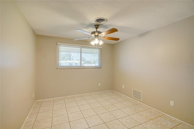 tiled spare room featuring a textured ceiling and ceiling fan