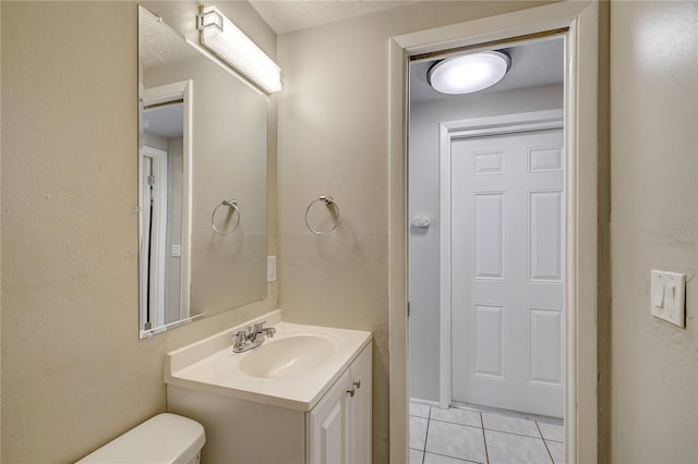 bathroom with tile patterned flooring, vanity, and toilet