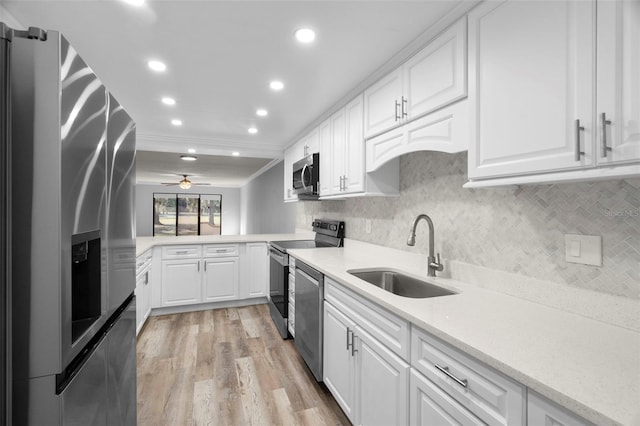 kitchen featuring ceiling fan, sink, crown molding, appliances with stainless steel finishes, and white cabinets