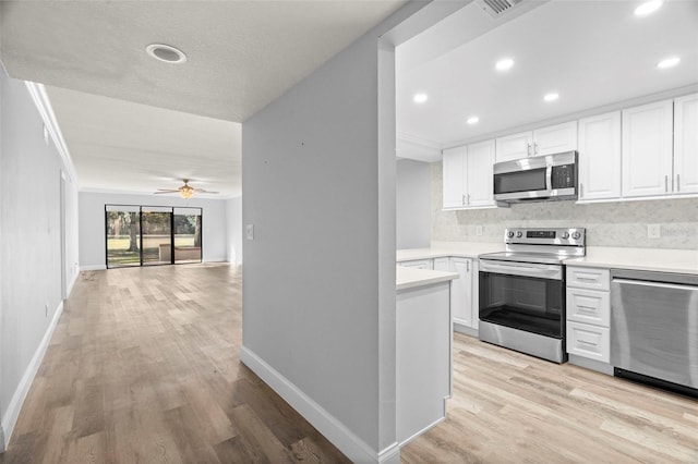 kitchen with ceiling fan, backsplash, white cabinetry, ornamental molding, and stainless steel appliances