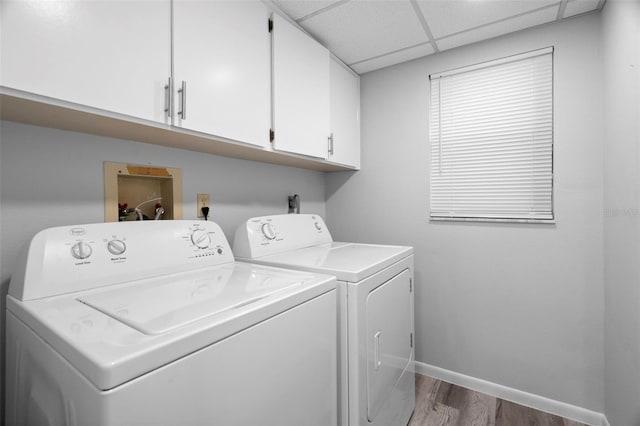 laundry room featuring cabinets, independent washer and dryer, and hardwood / wood-style floors