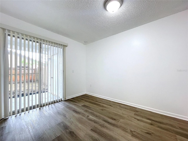 unfurnished room featuring dark hardwood / wood-style flooring and a textured ceiling