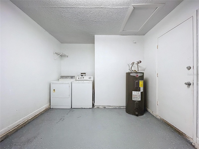 washroom featuring washing machine and dryer, water heater, and a textured ceiling