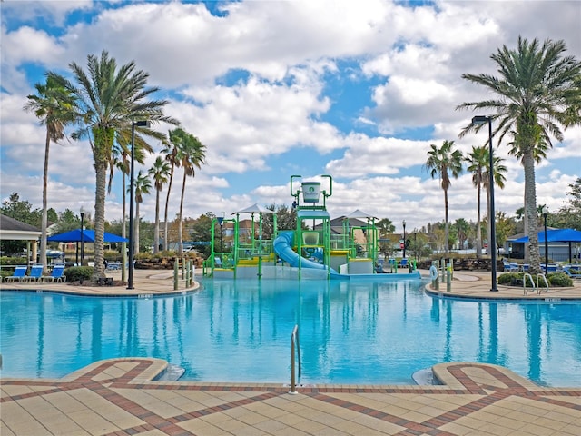 view of swimming pool with a playground and a water slide