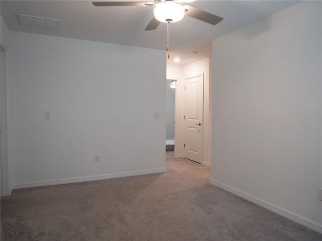 spare room featuring ceiling fan and light carpet