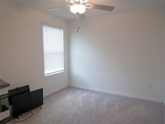 unfurnished office with light carpet, ceiling fan, and a healthy amount of sunlight