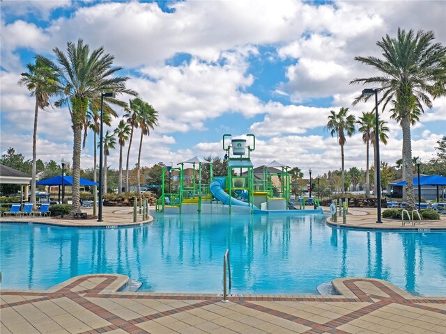 view of pool featuring a playground and a water slide