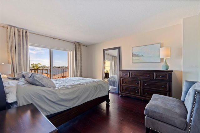 bedroom with access to exterior and dark wood-type flooring