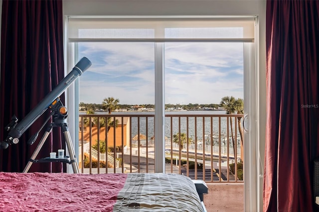 bedroom with a water view and multiple windows