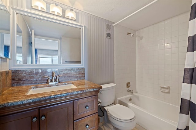 full bathroom with shower / bath combo with shower curtain, vanity, a textured ceiling, and toilet