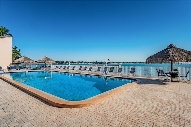 view of pool featuring a patio area and a water view